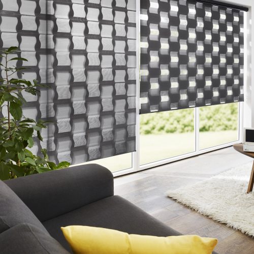 Helles Wohnzimmer mit Doppelrollo, Couch mit roten und gelben Kissen,  gelbe Wand und Teppich